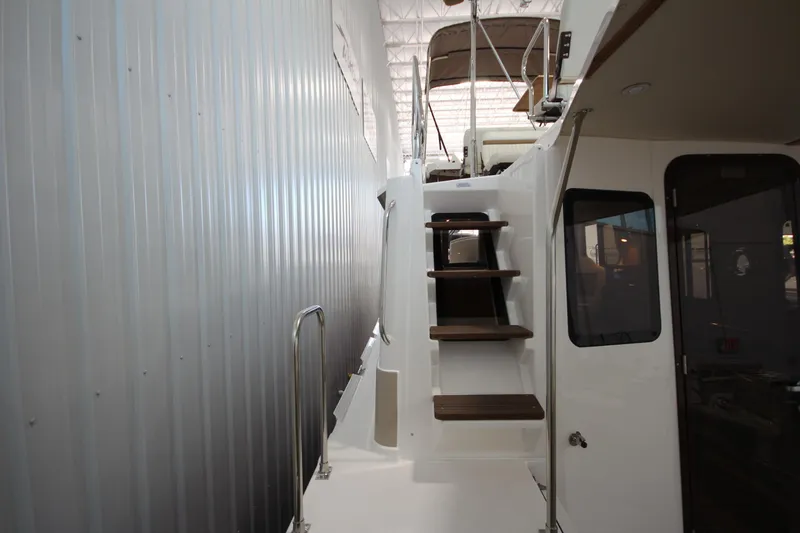 Slide: The Image of 2026 Ranger Tugs R-31 CB boat interior with wooden steps and modern design. - 22