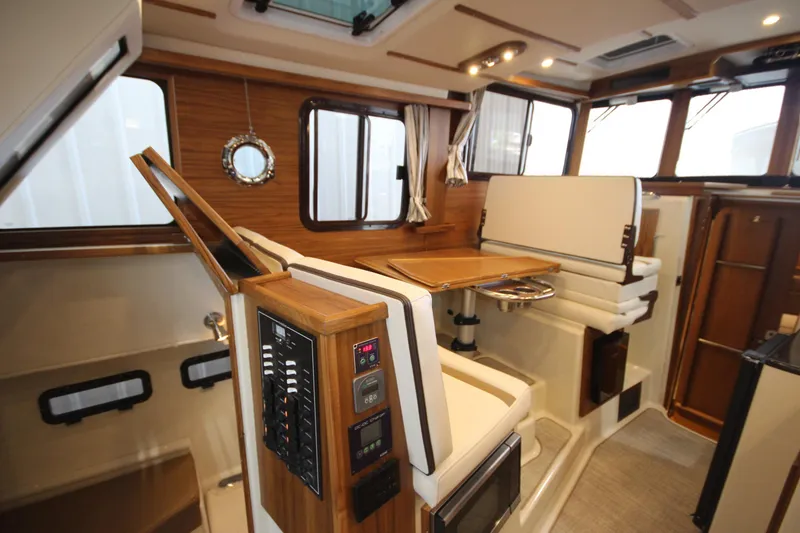 Slide: The Image of Interior of 2026 Ranger Tugs R-31 CB, featuring elegant wood finishes and modern seating. - 37