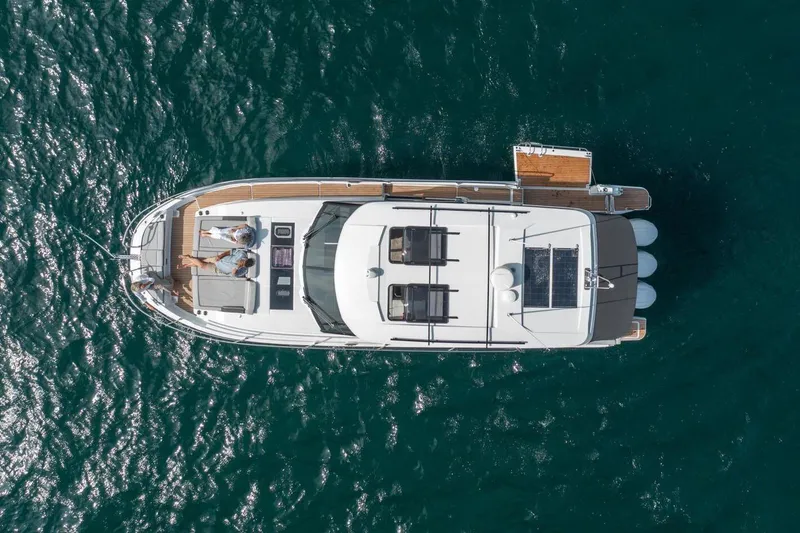 Slide: The Image of Manufacturer Provided Image: Overhead view of 2025 Jeanneau NC 1295 Coupe yacht on open water. - 11