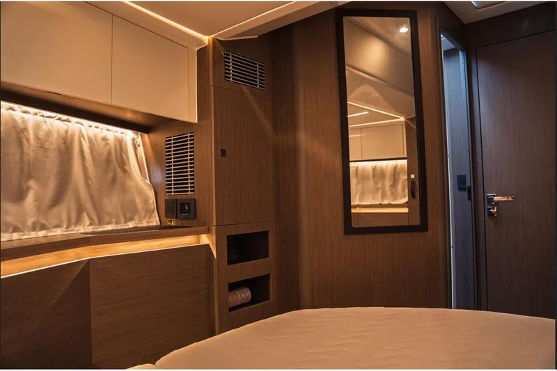 Slide: The Image of Interior cabin of 2025 Jeanneau NC 1295 Coupe, featuring modern wood finishes and ambient lighting. - 28