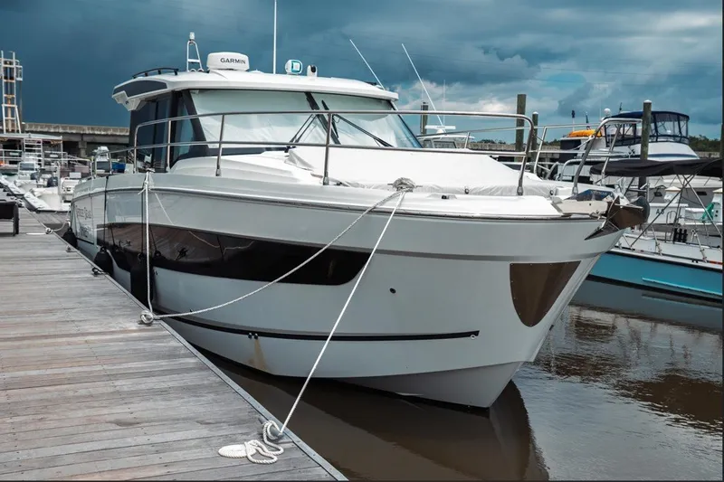 Slide: The Image of 2025 Jeanneau NC 1295 Coupe docked at marina under cloudy sky. - 5