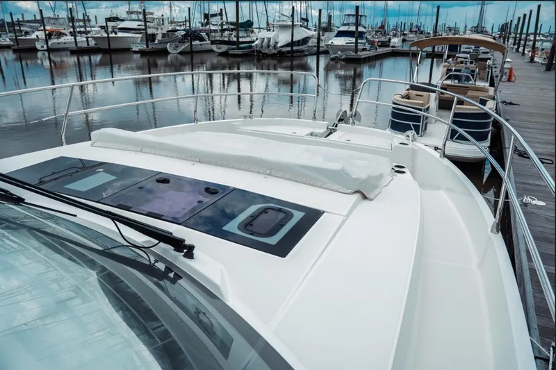 Slide: The Image of 2025 Jeanneau NC 1295 Coupe docked at marina, showcasing sleek design and spacious deck. - 8