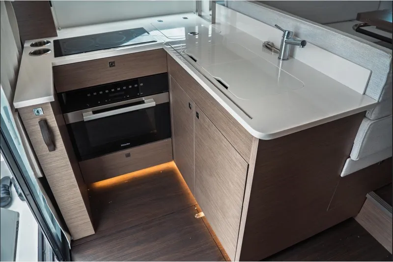 Slide: The Image of Modern kitchen area in 2025 Jeanneau NC 1295 Coupe yacht, featuring sleek cabinetry and appliances. - 18
