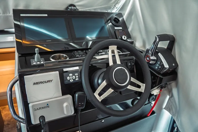 Slide: The Image of 2025 Jeanneau NC 1295 Coupe helm with Garmin and Mercury controls. - 17