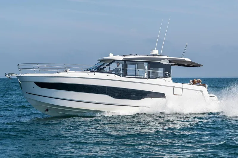 Slide: The Image of Manufacturer Provided Image: 2025 Jeanneau NC 1295 Coupe cruising on open water, showcasing sleek design and modern features. - 50