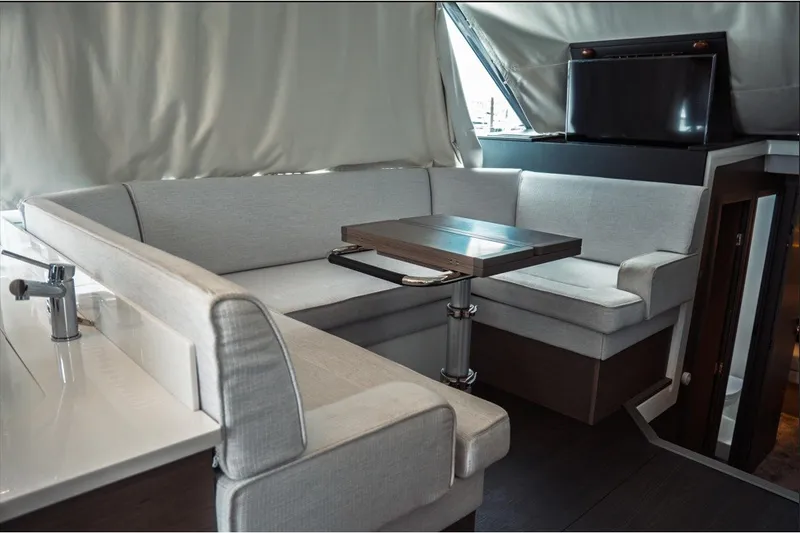 Slide: The Image of Interior of 2025 Jeanneau NC 1295 Coupe, featuring a modern seating area with a sleek table. - 23
