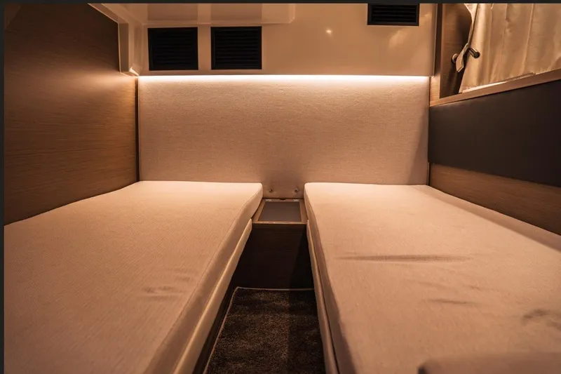 Slide: The Image of Interior cabin of 2025 Jeanneau NC 1295 Coupe with twin beds and ambient lighting. - 34