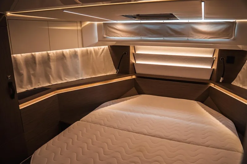 Slide: The Image of Luxurious cabin interior of 2025 Jeanneau NC 1295 Coupe with modern lighting and cozy bedding. - 26