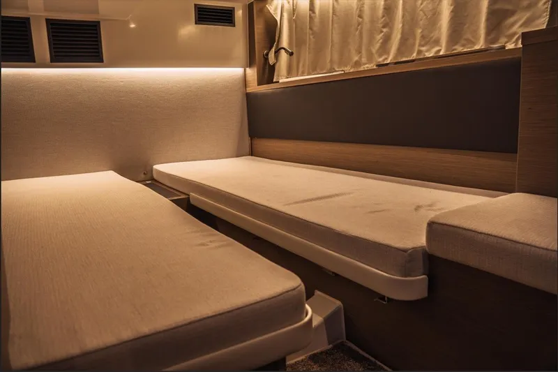Slide: The Image of Interior cabin of 2025 Jeanneau NC 1295 Coupe with twin beds and modern lighting. - 40