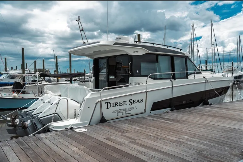 Slide: The Image of 2025 Jeanneau NC 1295 Coupe docked at marina under cloudy sky. - 4