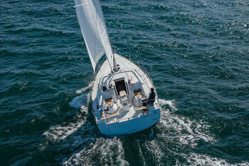 Slide: The Image of 2023 Beneteau Oceanis 38.1 sailing on open sea, viewed from above. - 0