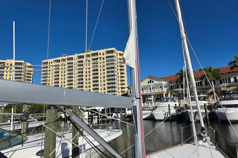 Slide: The Image of 2023 Beneteau Oceanis 38.1 sailboat docked at marina with waterfront buildings. - 69