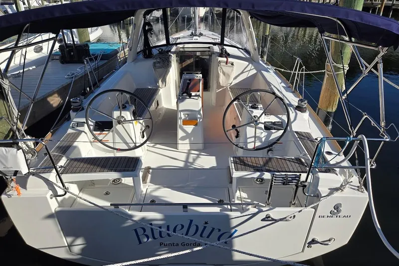 Slide: The Image of 2023 Beneteau Oceanis 38.1 sailboat docked, featuring dual steering wheels and spacious cockpit. - 98