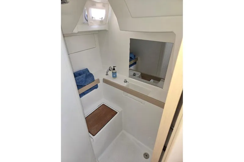 Slide: The Image of 2023 Beneteau Oceanis 38.1 bathroom with mirror, sink, and wooden accents. - 58