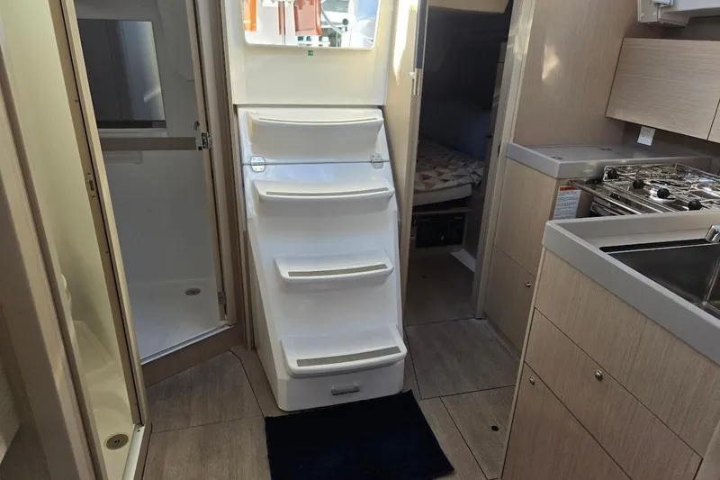 Slide: The Image of 2023 Beneteau Oceanis 38.1 interior with kitchen, stairs, and cabin view. - 50