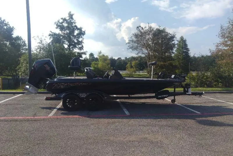 The Image of 2026 Nitro Z20 XL Pro boat parked in a lot, surrounded by trees. - 0