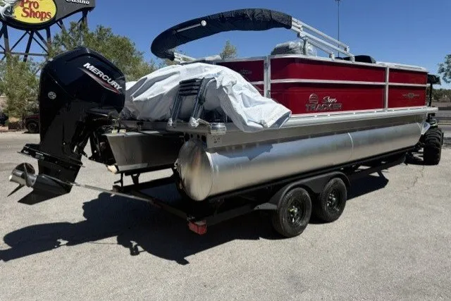 The Image of 2026 Sun Tracker Party Barge 20 DLX pontoon boat on trailer, featuring Mercury outboard motor. - 0