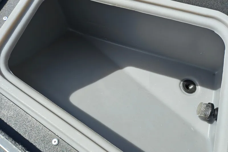 Slide: The Image of 2026 Tracker Pro Guide V-175 WT boat storage compartment, featuring a drain plug. - 25