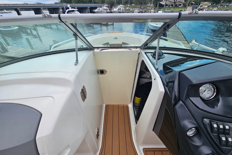 Slide: The Image of 2012 Monterey 244FS boat interior with open cabin door, dockside view. - 18