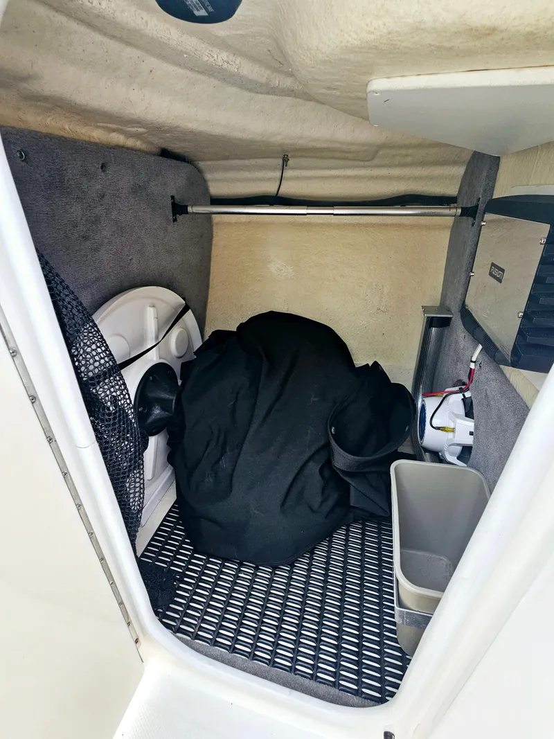 Slide: The Image of 2012 Monterey 244 FS boat storage compartment with various items and equipment. - 14