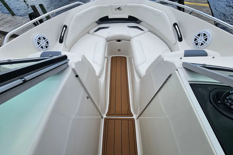 Slide: The Image of Interior view of a 2012 Monterey 244FS boat with white seating and wood flooring. - 17
