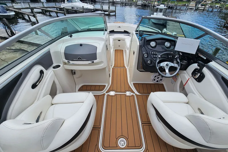 Slide: The Image of Interior of a 2012 Monterey 244FS boat with white seating and wooden flooring. - 15
