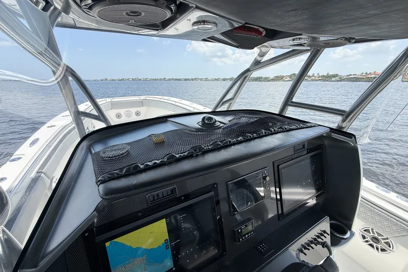 Slide: The Image of 2018 Nor-Tech 392 Super Fish boat cockpit with navigation screens on a calm water backdrop. - 24