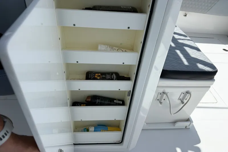 Slide: The Image of Open storage compartment on 2018 Nor-Tech 392 Super Fish boat, containing various bottles. - 29