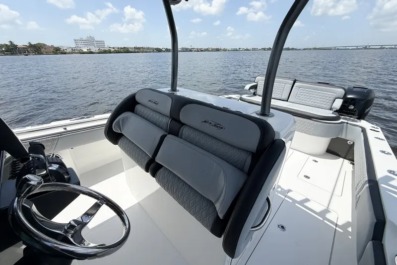 Slide: The Image of 2018 Nor-Tech 392 Super Fish boat interior with steering wheel and seating, on calm water. - 22