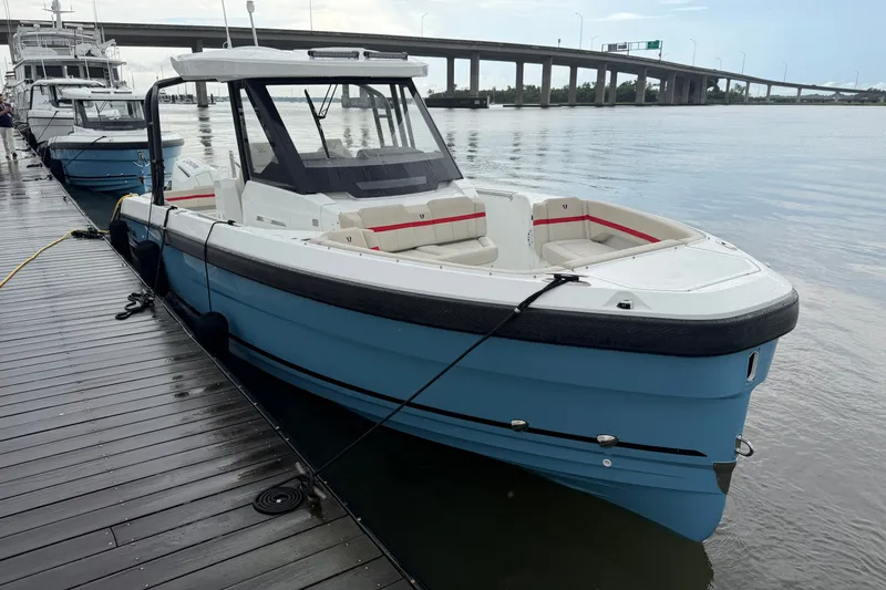 Slide: The Image of 2027 Wellcraft 28 T-Top boat docked by a scenic waterfront bridge. - 7