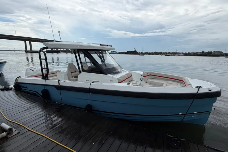 Slide: The Image of 2027 Wellcraft 28 T-Top boat docked by the water under a cloudy sky. - 5