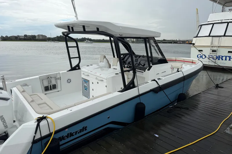 Slide: The Image of 2027 Wellcraft 28 T-Top boat docked, featuring sleek design and spacious seating. - 6