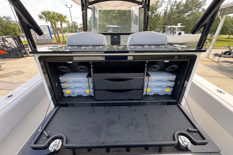 Slide: The Image of 2024 Fountain 34 Center Console boat with open storage compartments and tackle boxes. - 41