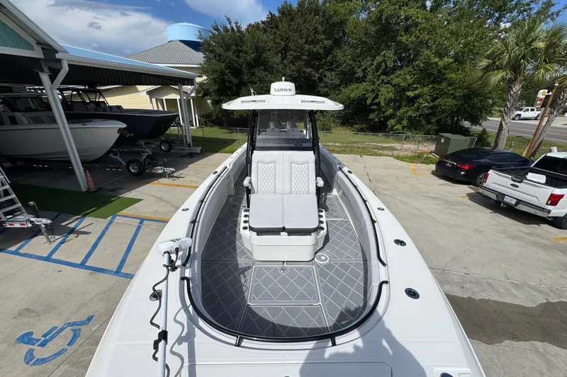 Slide: The Image of 2024 Fountain 34 Center Console boat docked, showcasing sleek design and spacious deck. - 25