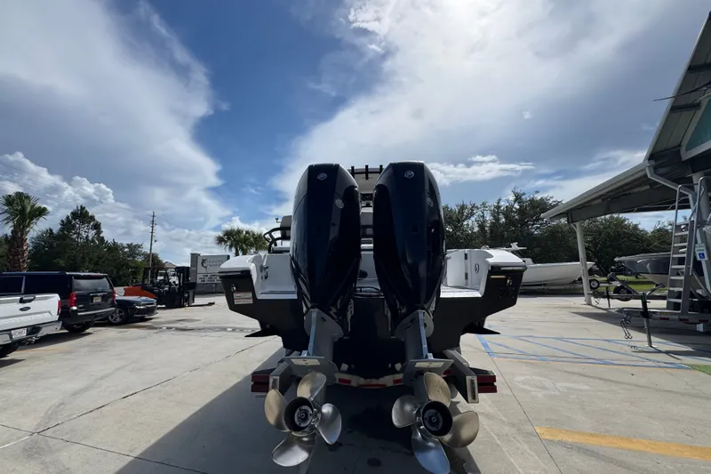 Slide: The Image of 2024 Fountain 34 Center Console boat with dual outboard motors in a sunny marina. - 16