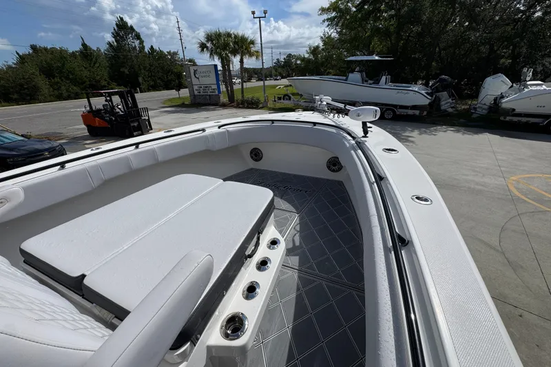 Slide: The Image of 2024 Fountain 34 Center Console boat with spacious seating and sleek design in a marina setting. - 20