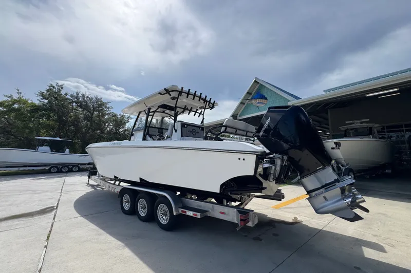Slide: The Image of 2024 Fountain 34 Center Console boat on trailer, parked outside a marina. - 19