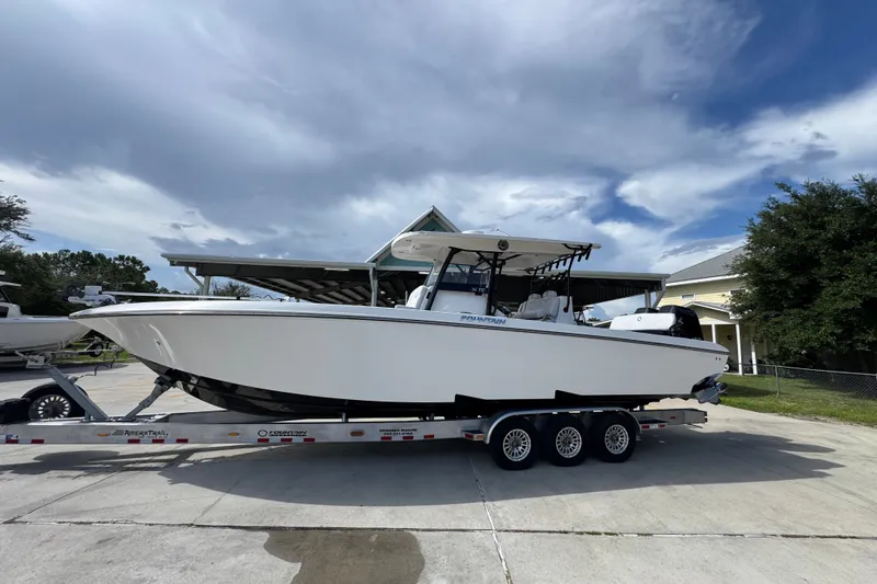 Slide: The Image of 2024 Fountain 34 Center Console boat on trailer under cloudy sky. - 2