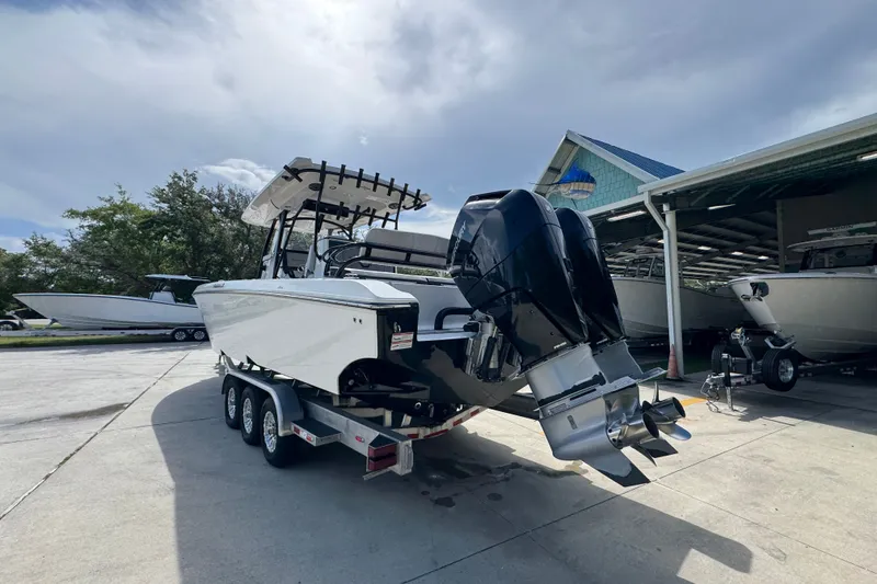 Slide: The Image of 2024 Fountain 34 Center Console boat on trailer, dual outboard motors, parked outdoors. - 18