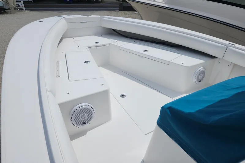 Slide: The Image of 2005 Regulator 26 Forward Seating boat interior with white seating and storage compartments. - 19