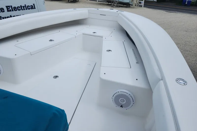 Slide: The Image of 2005 Regulator 26 Forward Seating boat interior with white cushioned seats and storage compartments. - 18