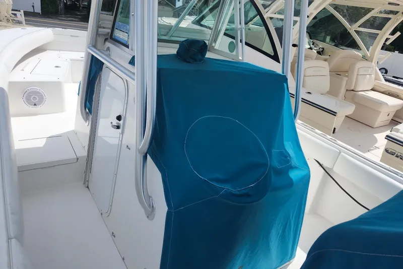 Slide: The Image of 2005 Regulator 26 Forward Seating boat interior with blue covers and white seating. - 21