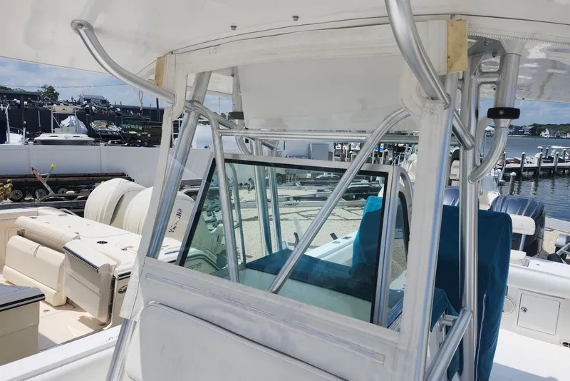 Slide: The Image of 2005 Regulator 26 Forward Seating boat at marina, featuring sturdy frame and seating. - 14