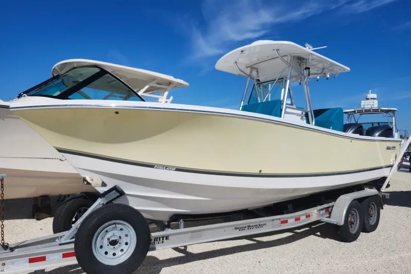 The Image of 2005 Regulator 26 Forward Seating boat on trailer under clear blue sky. - 0