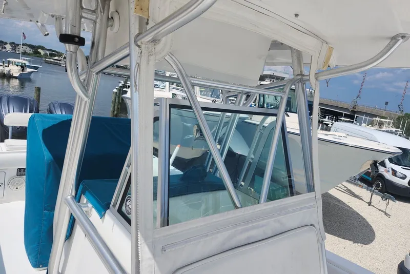 Slide: The Image of 2005 Regulator 26 Forward Seating boat with blue upholstery, docked near marina. - 15