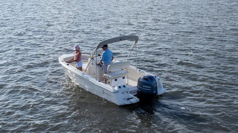 Slide: The Image of Two people ride a Scout 188 Sportfish boat on calm waters. - 3