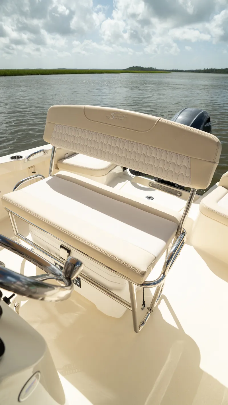 Slide: The Image of The 2027 Scout 188 Sportfish features a cushioned bench seat, set on calm waters. - 31