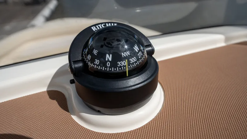 Slide: The Image of A compass on a boat, mounted on a beige surface. - 11