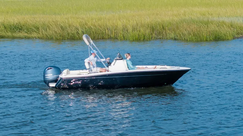 Slide: The Image of A 2027 Scout 188 Sportfish on calm waters with two people on board. - 48