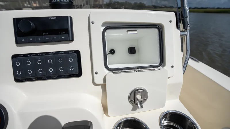 Slide: The Image of The image shows the dashboard of a Scout 188 Sportfish boat with controls and a small compartment. - 10